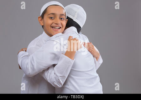 Les jeunes garçons musulmans à l'aide de capuchons serrant les uns les autres Banque D'Images