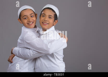 Les jeunes garçons musulmans, avec des plafonds de l'autre côté hugging Banque D'Images