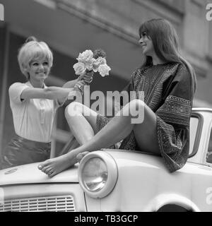 07.07.1971, Berlin, Berlin, RDA, photo de mode, jeune femme mains fleurs à son ami assis sur une Trabant. 00S710707D003CAROEX.JPG [communiqué de modèle : Banque D'Images