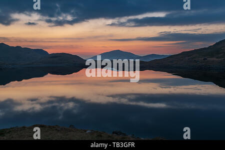 Lever de soleil à Snowdonia, heure d'or et rouge moody skies tôt le matin. Banque D'Images