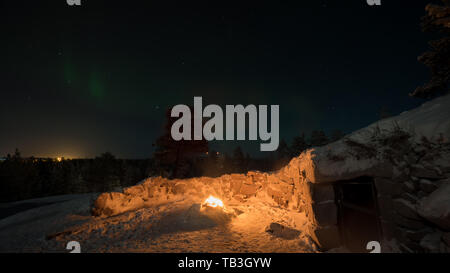 La lumière chaude du feu et lumières polaires au ciel nocturne Banque D'Images