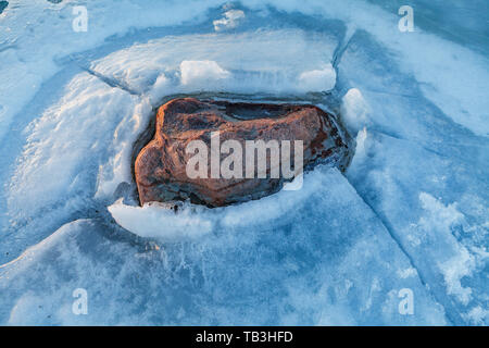 Voir l'avant au-dessus de close up boulder congelé au bord de la mer. Glace sur une pierre. Banque D'Images