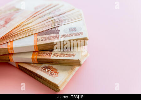 Pile de 5000 roubles packs isolé sur rose. Le concept de la richesse, les bénéfices, l'administration et des finances. L'argent de la pile dans le cinq millième projets de billets en euros Banque D'Images