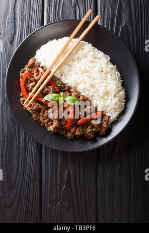 Délicieux avec du boeuf basilic poivrons, l'ail et les oignons, servi avec du riz libre sur une plaque sur la table. Haut Vertical Vue de dessus Banque D'Images