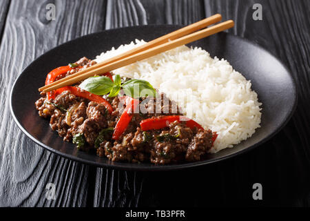 Boeuf Basilic thaï traditionnel, ou un Pad Gra proue sur le riz blanc gros plan sur une assiette sur la table horizontale. Banque D'Images