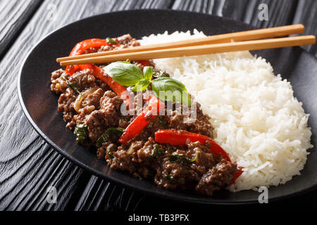 Délicieux avec du boeuf basilic poivrons, l'ail et les oignons, servi avec du riz libre sur une plaque sur la table horizontale. Banque D'Images