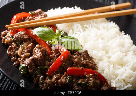 Le basilic boeuf aux poivrons dans une sauce épicée servi avec du riz sur une plaque horizontale sur la table. Banque D'Images