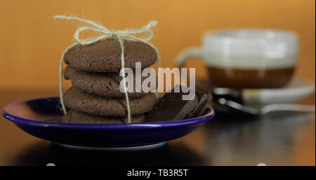 Délicieux chocolat à biscuit sur une plaque bleue sur la surface sombre. Vintage fond chaud Banque D'Images