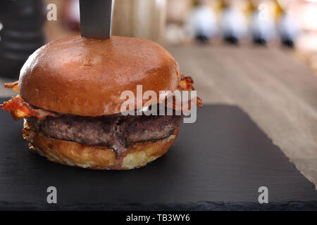 Burger de boeuf avec du bacon. Boeuf grillé escalope dans un petit pain. Banque D'Images