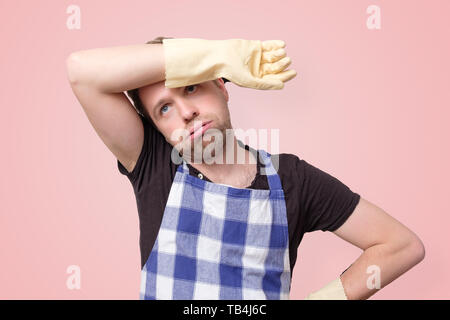 Homme portant des gants de caoutchouc pour la protection des mains essuyant la sueur Banque D'Images