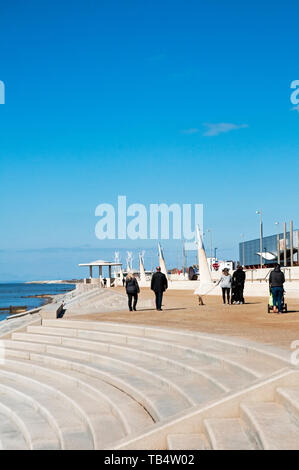 Les gens qui marchent le long de la promenade sur une journée ensoleillée au-dessus des mesures modernes de la plage à Cleveleys Lancashire England UK Banque D'Images