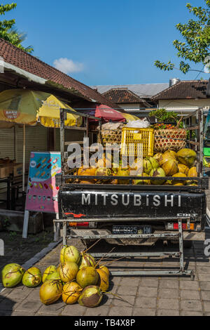 Banjar Gelulung, Bali, Indonésie - 26 Février 2019 : Coconut homme vend sa marchandise hors de l'arrière du camion Mitsubishi en face de Batuan Temple. Banque D'Images