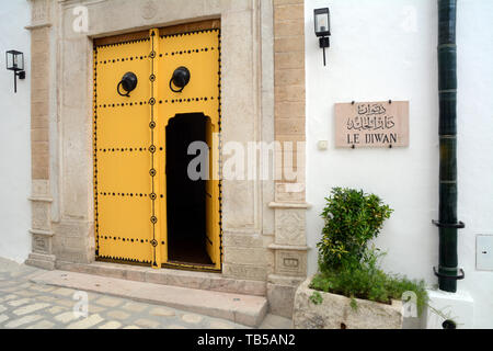 La Porte jaune traditionnel à un restaurant de luxe dans un bâtiment du xvie siècle dans une ruelle de la médina (vieille ville) de Tunis, Tunisie. Banque D'Images