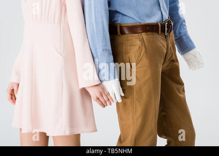 Portrait of Girl holding hands with mannequin isolé sur gray Banque D'Images