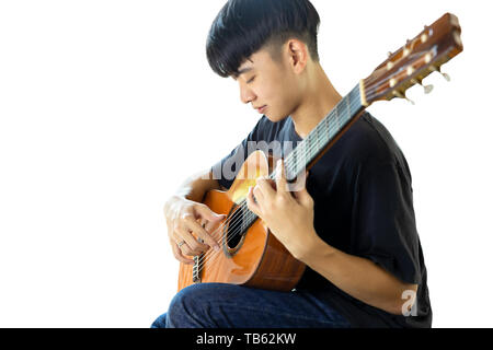 Asian man jouer a la guitare classique isolé sur fond noir Banque D'Images