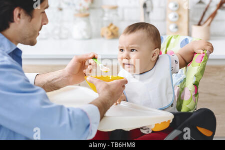 Enfants dégoûtant de la nutrition. Mignon bébé froncer le nez, ne veut pas manger le repas de papa, de l'espace libre Banque D'Images