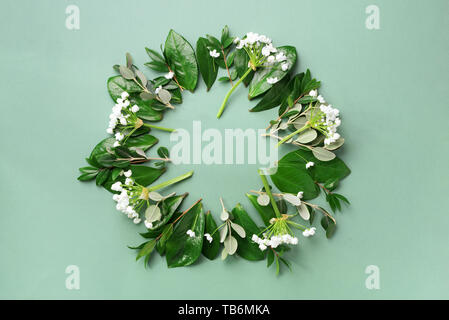 Mise en page créative faite de feuilles tropicales et des fleurs blanches sur fond vert. Vue d'en haut. Mise à plat. L'été ou printemps nature concept. Vide pour publicité Banque D'Images