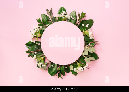 Mise en page créative faite de feuilles tropicales vert et de fleurs blanches sur fond rose. Vue d'en haut. Mise à plat. L'été ou printemps nature concept. Cache pour l'adv Banque D'Images