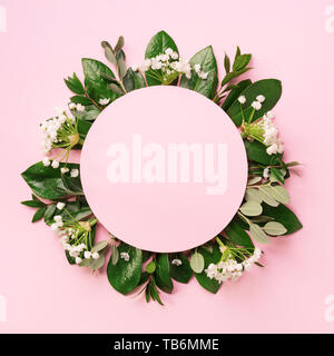 Mise en page créative faite de feuilles tropicales vert et de fleurs blanches sur fond rose. Vue d'en haut. Mise à plat. L'été ou printemps nature concept. Cache pour l'adv Banque D'Images