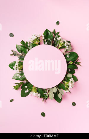 Mise en page créative faite de feuilles tropicales vert et de fleurs blanches sur fond rose. Vue d'en haut. Mise à plat. L'été ou printemps nature concept. Cache pour l'adv Banque D'Images