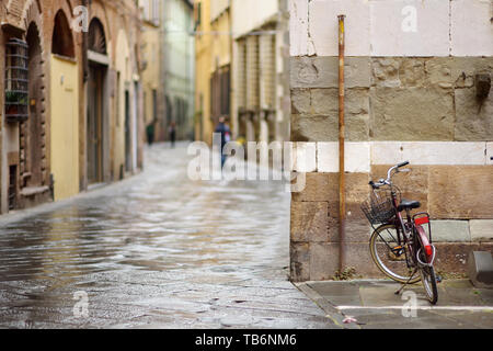 Les vélos garés sur les belles rues médiévales de Lucques, ville connue pour sa ville de l'époque Renaissance intacts les murs, Toscane, Italie. Banque D'Images