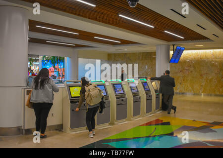 Orlando, Floride. 01 mars, 2019. Femme à l'aide de self service d'enregistrement à l'Aéroport International d'Orlando . Banque D'Images