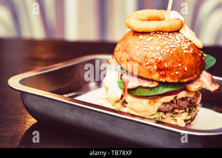 Close up tall tasty burger avec fromage servi sur le bac Banque D'Images