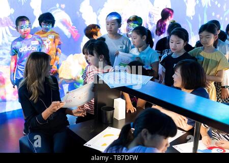 Première Dame des États-Unis Melania Trump se réunit avec les élèves dans la création d'être meilleur artwork lors de sa tournée de l'équipe sans marge de laboratoire à l'exposition du Musée d'art Mori Building Digital, 26 mai 2019 à Tokyo, Japon. Banque D'Images