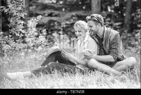 Date romantique au pré vert. Couple in love dépenser livre la lecture de détente. Les étudiants bénéficient de couple romantique avec poésie loisirs nature background. Deux âmes soeurs à date romantique. Week-end agréable. Banque D'Images