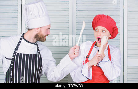 Règles de cuisine. Bataille culinaire concept. Femme et homme barbu show culinaire concurrents. Qui mieux cuisiner. Cuisine ultime défi. Bataille de deux chefs culinaires. La concurrence dans quelques arts culinaires. Banque D'Images