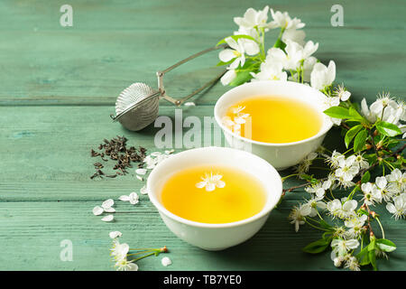 Une tasse de thé de pétales de fleurs parfumées blanches en forforkovy tasses sur un fond de bois. Focus sélectif. Copier l'espace. Banque D'Images