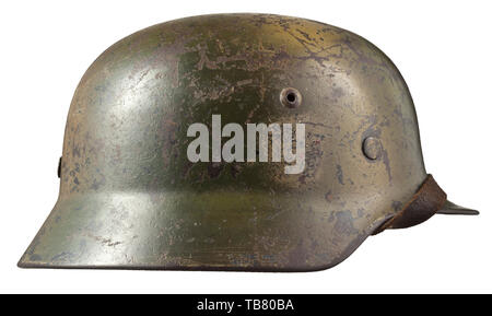 Un casque d'acier M 35 avec de la peinture de camouflage, le crâne gravé sur l'intérieur de 'E64' (Suisse saxonne) Emaillierwerke, petites perforations sur le côté gauche causée par une coquille splinter. Multi-couleur camouflage appliqué sur l'original de la peinture gris-Luftwaffe, les vestiges des deux emblèmes visible sous le camouflage. Complet avec revêtement intérieur et jugulaire historique., historique du 20e siècle, Editorial-Use-seulement Banque D'Images