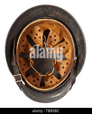 Un casque d'acier M 35 avec de la peinture de camouflage, le crâne gravé sur l'intérieur de 'E64' (Suisse saxonne) Emaillierwerke, petites perforations sur le côté gauche causée par une coquille splinter. Multi-couleur camouflage appliqué sur l'original de la peinture gris-Luftwaffe, les vestiges des deux emblèmes visible sous le camouflage. Complet avec revêtement intérieur et jugulaire historique., historique du 20e siècle, Editorial-Use-seulement Banque D'Images
