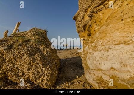 Le passage entre les rochers sur la plage de sable Banque D'Images