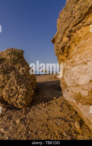 Le passage entre les rochers sur la plage de sable Banque D'Images