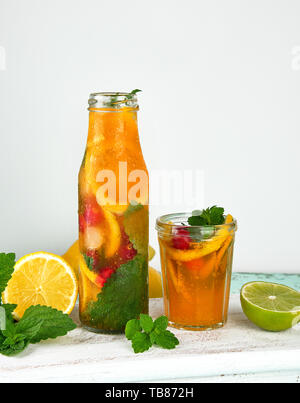 Boisson rafraîchissante de l'été avec de la limonade citron, canneberge, feuilles de menthe, la chaux dans une bouteille en verre, à côté les ingrédients pour faire un cocktail Banque D'Images