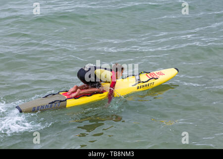 Bournemouth, Dorset, Royaume-Uni. 31 mai 2019. Météo au Royaume-Uni : nuageux et frénétique sur les plages de Bournemouth, les températures devraient augmenter pour le week-end. RNLI Lifeguard sur planche de surf. Crédit : Carolyn Jenkins/Alay Live News Banque D'Images