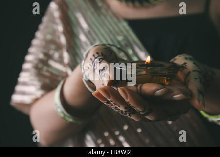 Belle femme avec bougie allumée pour la célébration de Divaly, gros plan Banque D'Images