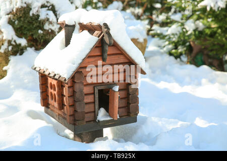 Mangeoire en bois en forme de chambre le jour d'hiver Banque D'Images