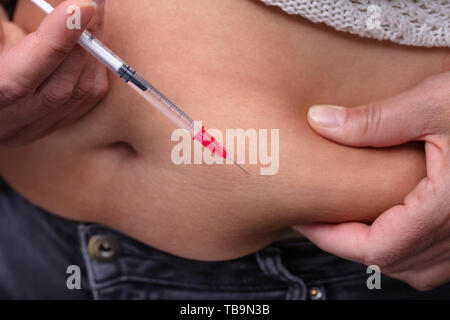 Close Up of Woman s'injecter des drogues sur son ventre Banque D'Images
