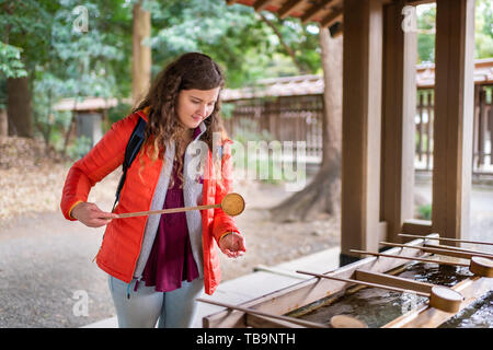 Tokyo, Japon Meiji Shrine fontaine de purification de l'eau entrée d'affaires femme fille personne au printemps, se laver les mains Banque D'Images