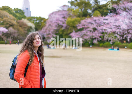 Tokyo, Japon cerisiers avec des fleurs au printemps Le printemps à Shinjuku gyoen avec les gens sur le terrain femme touristiques pré avec sac à dos Banque D'Images