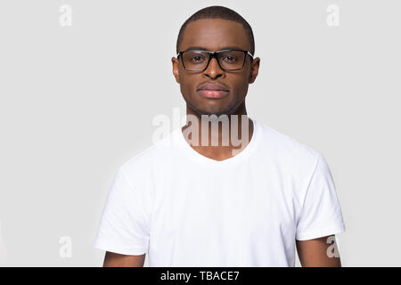 African Male wearing glasses t-shirt blanc qui pose à l'intérieur Banque D'Images