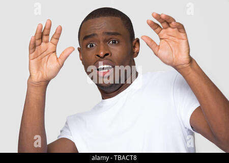 African Male looking at camera font de grands yeux se sent effrayé Banque D'Images