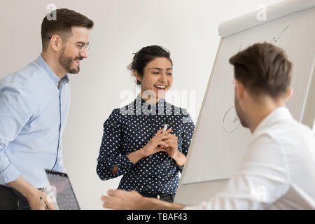 Smiling divers employés près de brainstorming exposé au tableau blanc Banque D'Images