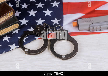 Pistolet et menottes sur un drapeau américain en application de la loi aux États-Unis. Banque D'Images