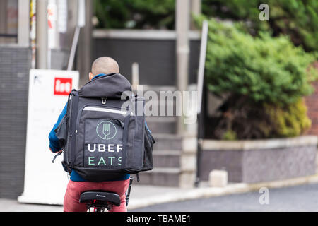 Tokyo, Japon - 30 mars 2019 : Shibuya street road à dos de young delivery man on bicycle pour uber mange Banque D'Images