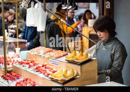 Tokyo, Japon - 31 mars 2019 : Ginza Tsukiji avec beaucoup de gens en marché par cantaloup fruits Aliments femme du vendeur et de l'affichage signe sur street Banque D'Images