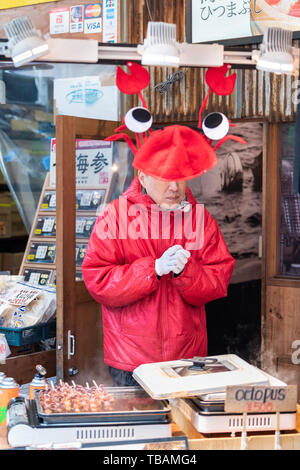 Tokyo, Japon - 30 mars 2019 : dans la rue du marché Tsukiji près de Ginza avec du poisson grillé, des vendeurs d'aliments sur la pieuvre et humour drôle decoration Banque D'Images