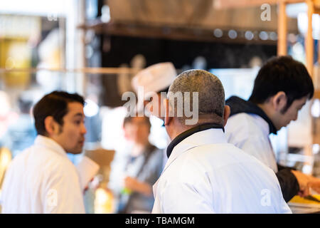 Tokyo, Japon - 30 mars 2019 : marché extérieur dans la rue près de Tsukiji Ginza avec les gens du vendeur de préparer des aliments cuisson gros plan Banque D'Images